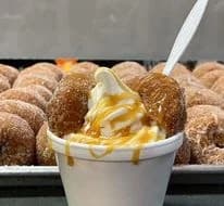 Soft serve sundae with a donut against a Lewis Farms background